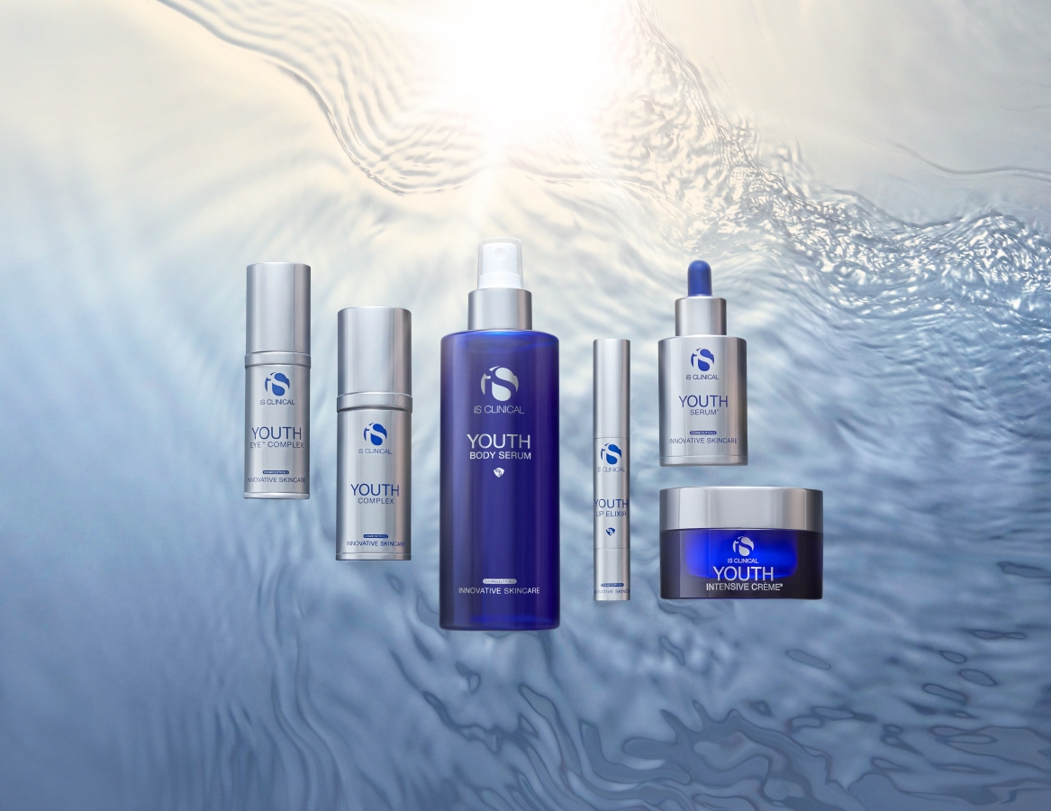 Five iS CLINICAL skincare products featured on a water background.