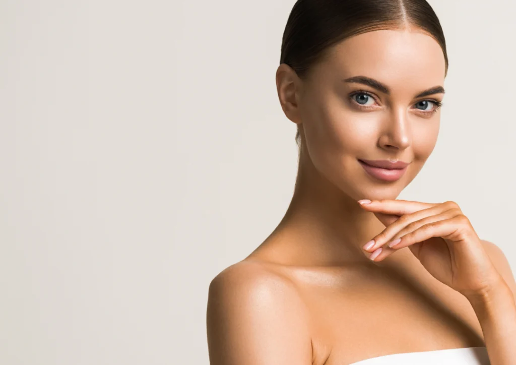 A woman with smooth, radiant skin touching her face confidently after a Skinvive session.