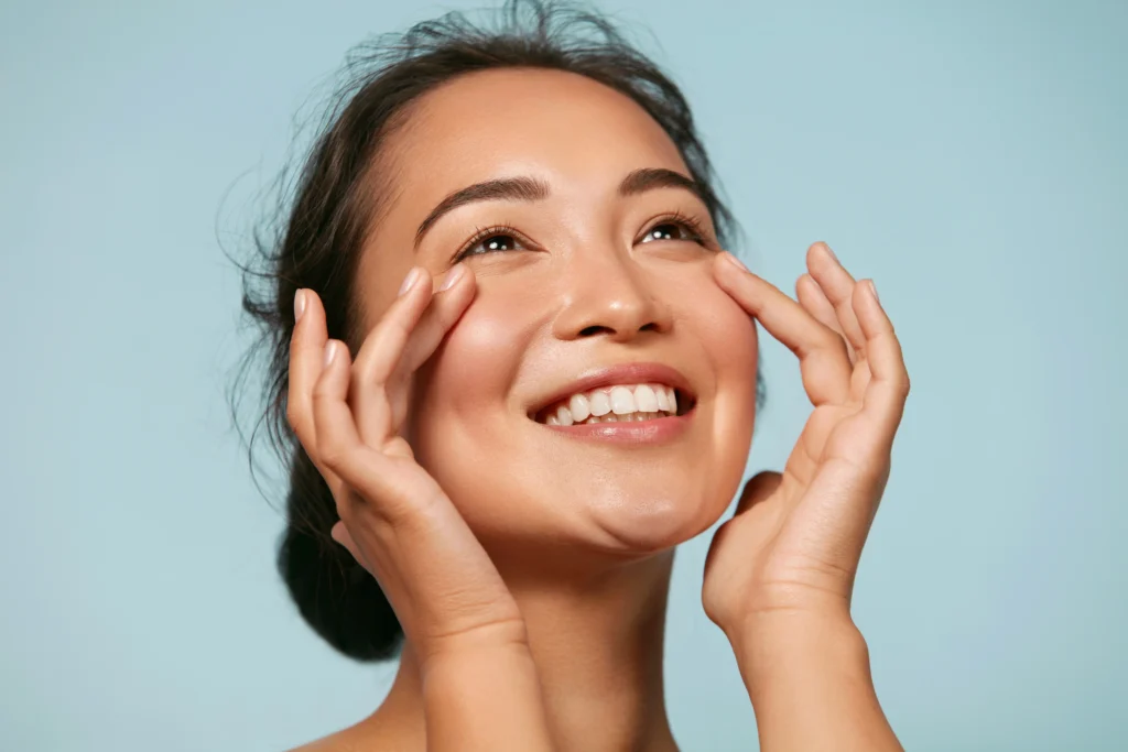 Smiling person touching the cheek area with both hands
